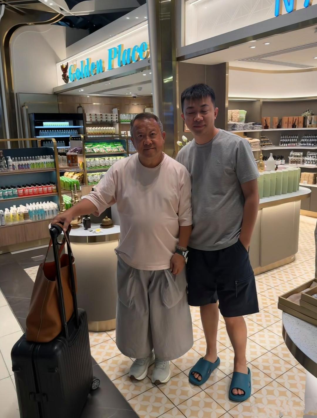 曾志伟推着拉杆箱在泰国独自逛商场，没有见到他的女性知己相伴左右，一个人很是孤独。