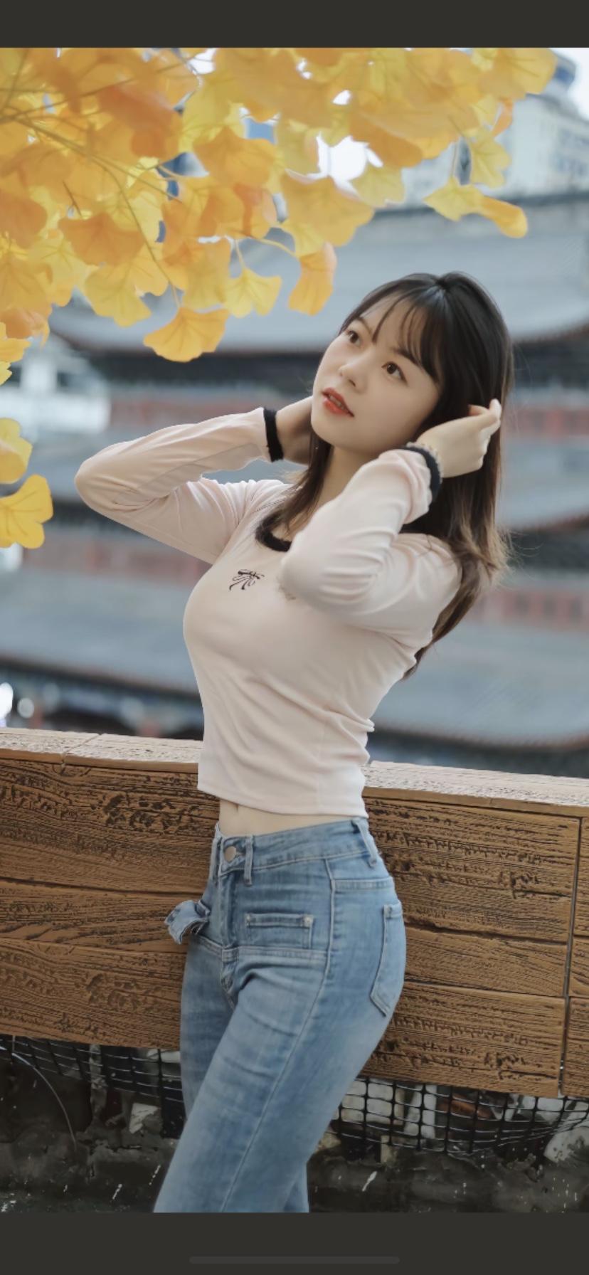 秋日暖阳下，少女轻抚发梢，落叶纷飞，唯美如画。