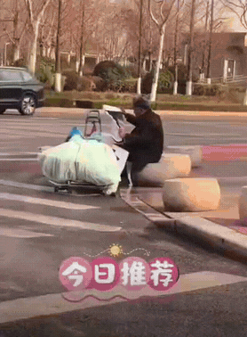 拾荒大爷算是捡到宝了!一位拾荒老人捡到一张别人的结婚海报，大爷坐在马路边，小