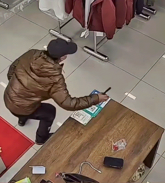 聪明过头了！辽宁鞍山，一男子趁其服装店前台无人看管之时，偷偷摸摸的将桌面上手机偷