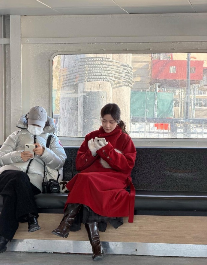 28岁徐娇在美国旅游被偶遇，她穿着红色大衣和长筒皮靴，化着精致的妆容，看起来很贵