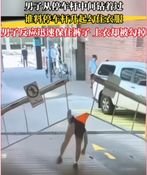 原谅我不厚道的笑了！一男子从停车杆中间钻着过去，没想到停车杆升起时，一边勾住了上