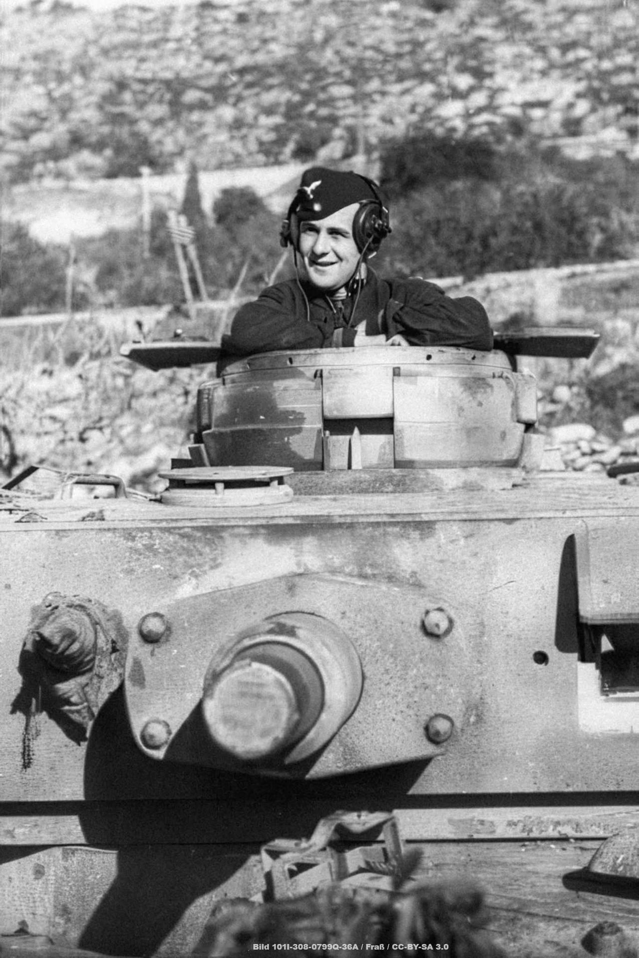 1943年，意大利境内，一名德国坦克兵佩戴耳机，身处一辆配备四号坦克炮塔（装有7