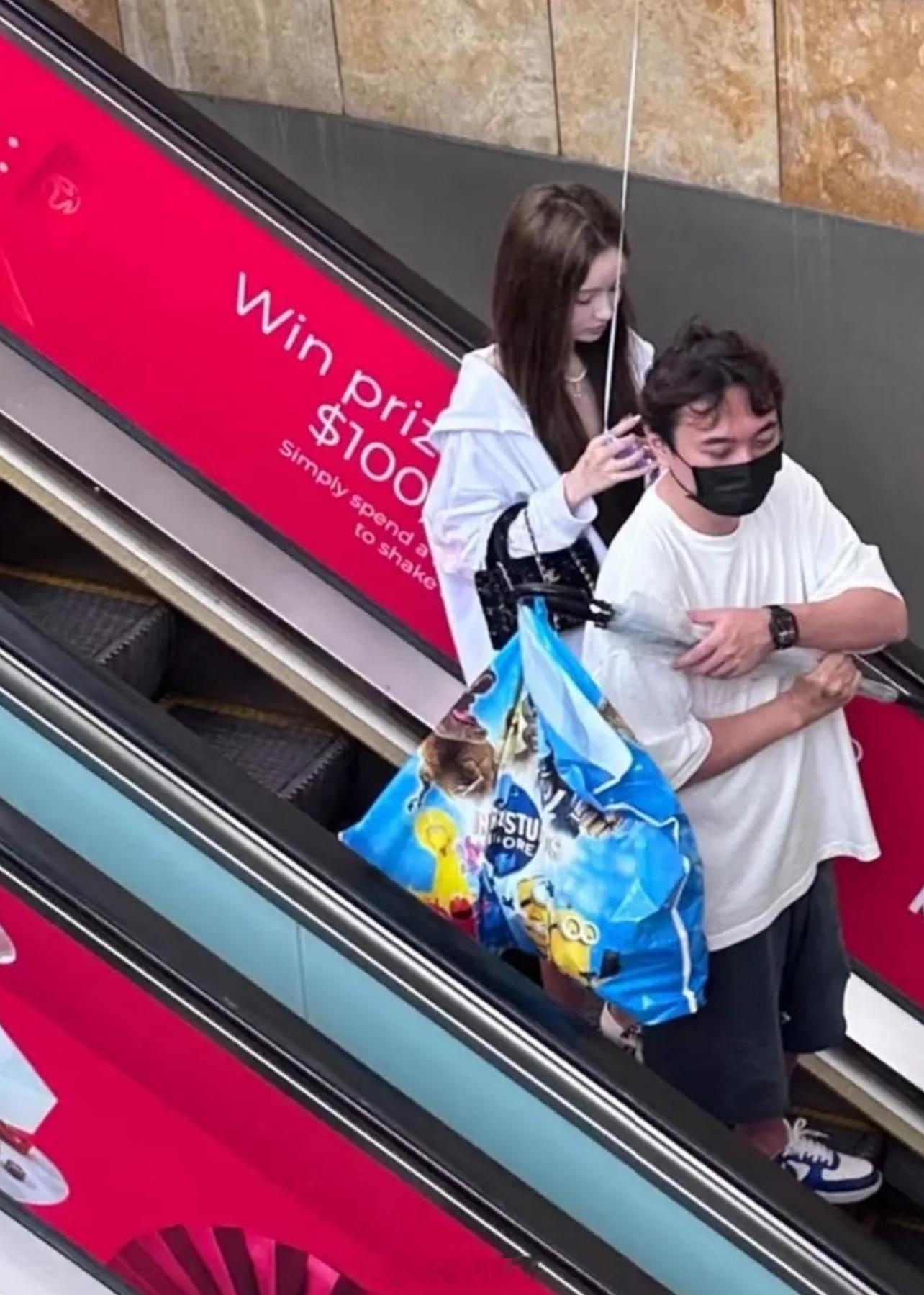 38岁王思聪和女友懒懒在新加坡过年，两个人一起到商场购物，他帮女友提着购物袋，看