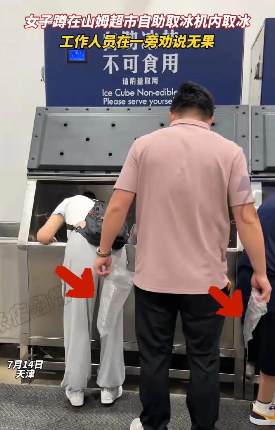 女子蹲在山姆制冰机里取冰，工作人员在一旁劝说，女子根本不听，继续蹲在里面取冰。