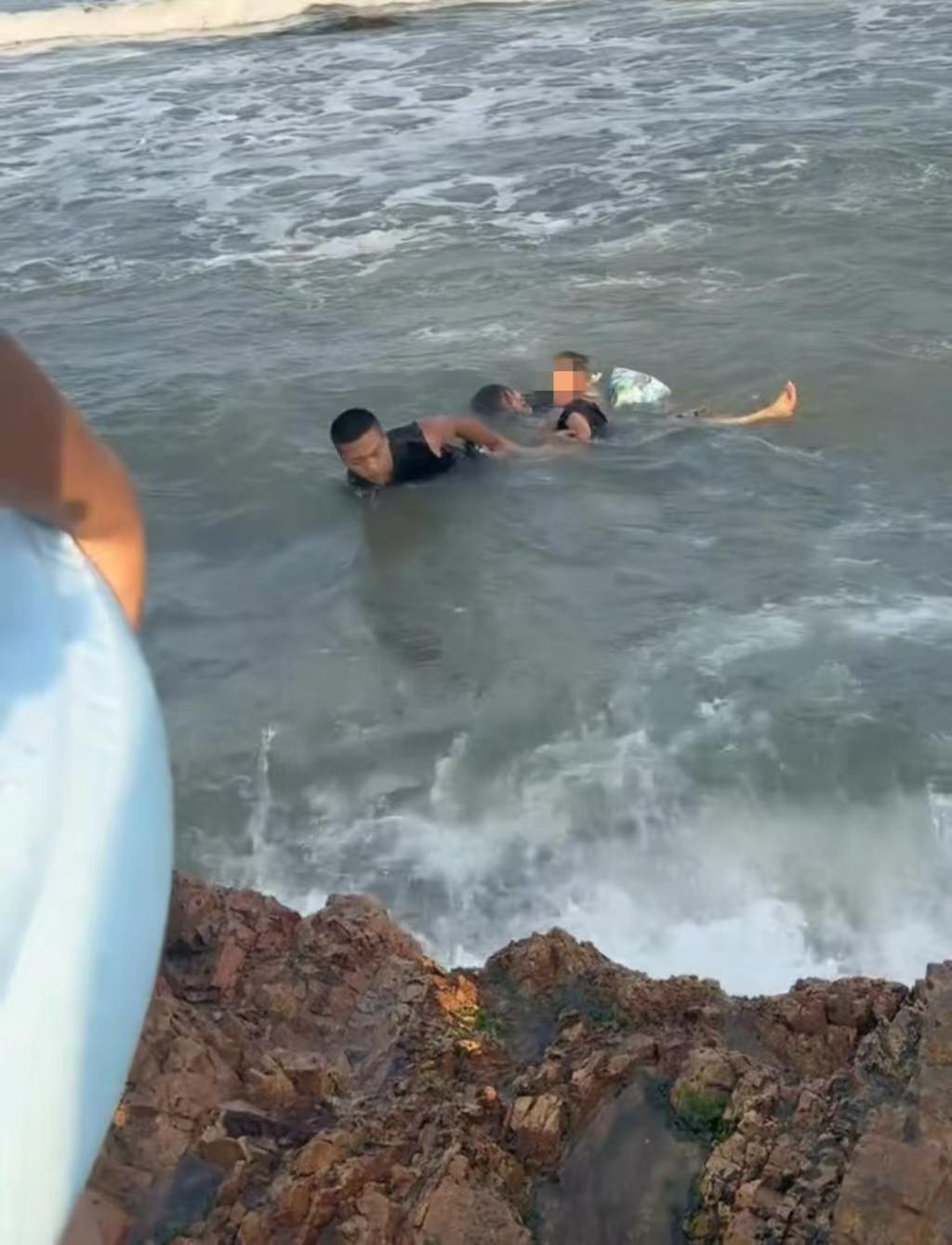 青岛，一对母子被卷入海浪，眼看就要被拖进深海了，一32岁的摄影师毫不犹豫地把相机