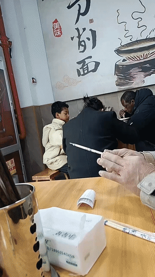 网友拍到一名女子带着她的非洲黑人老公以及他们的中非混血儿子在一家面馆里吃饭。这