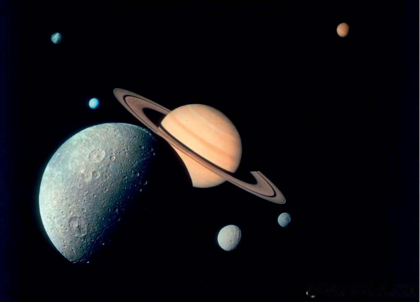 1980年11月“旅行者1号”飞船拍摄的土星及其卫星。图中土星正前方的是土卫四（