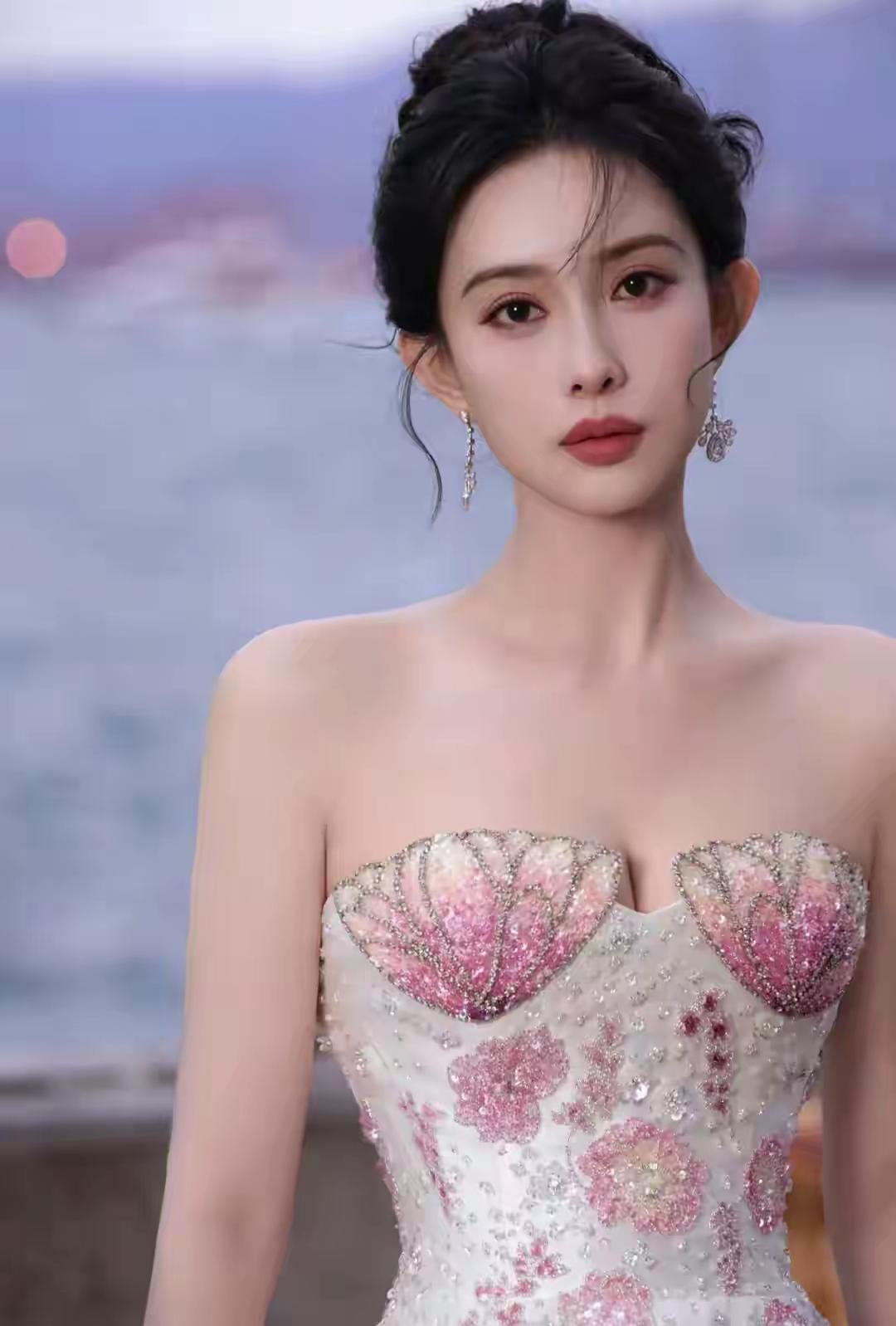 海浪漫过堤岸的黄昏，孟子义裹着一身“贝壳裙”站在风里——抹胸上粉白渐变的贝壳纹路