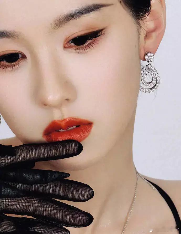 陈都灵妆容精致，红唇亮眼，佩戴钻石耳环，妩媚动人。