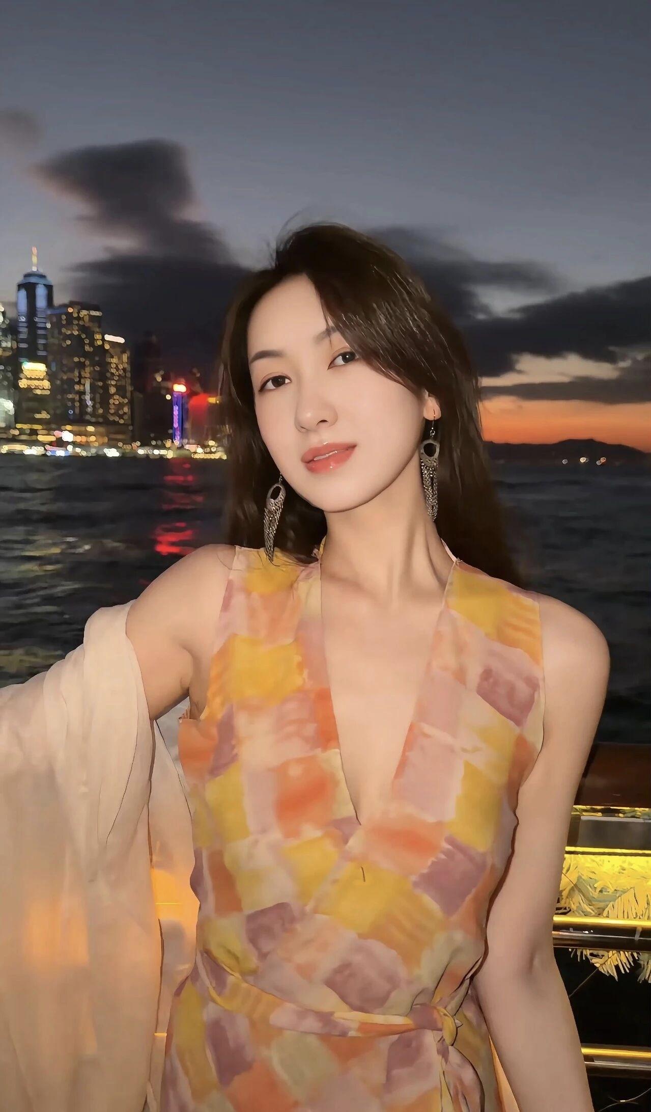 黄昏下的都市夜景，与她优雅的背影相映成趣。