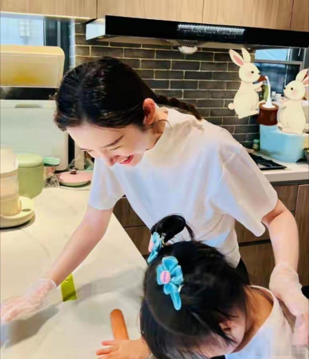 唐艺昕扎着低马尾在厨房带女儿做饼干，白T恤衬得皮肤透亮，笑起来眼尾弯成月牙——小
