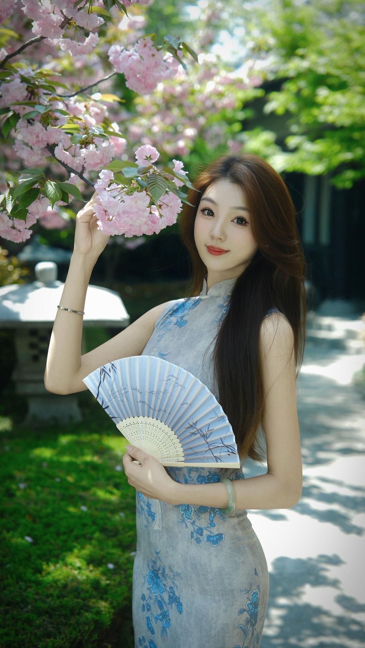 女人真正的气质是什么？浅灰旗袍缀青花，与晚樱同框，把东方女子的温婉写进了风里。