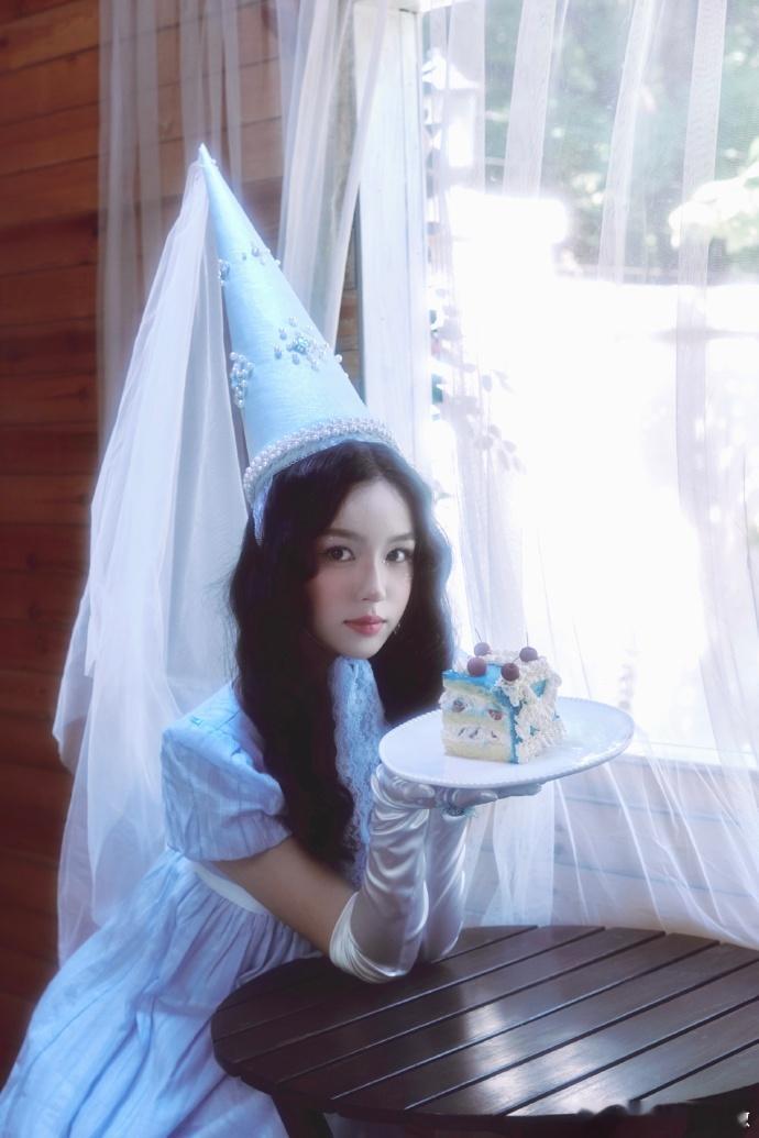 周也生日照像童话里的公主被周也的生日造型美晕！尖顶帽配蓝裙子，背景的小洋楼和彩