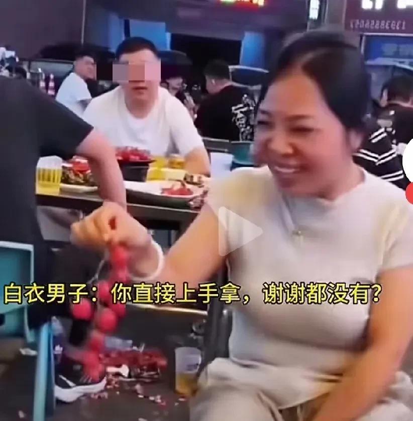这女子看到别人桌上西红柿很好，直接上手拿，嬉皮笑脸，自己觉得很可爱，不知道别人觉