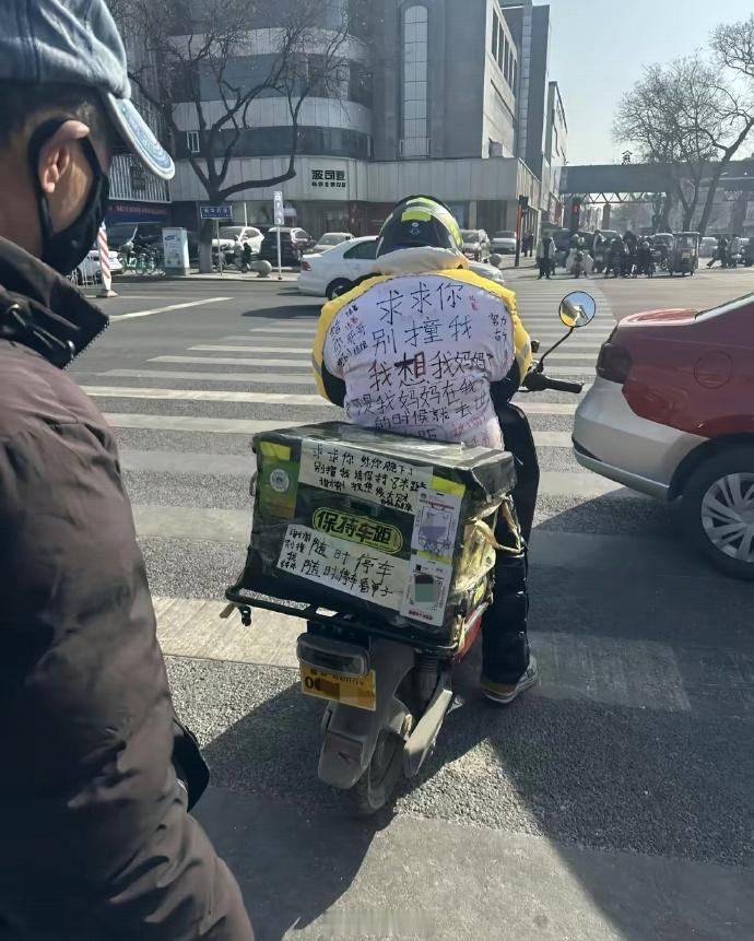 外卖小哥不容易，但还是要遵守交通规则，随时停车看手机谁受得了