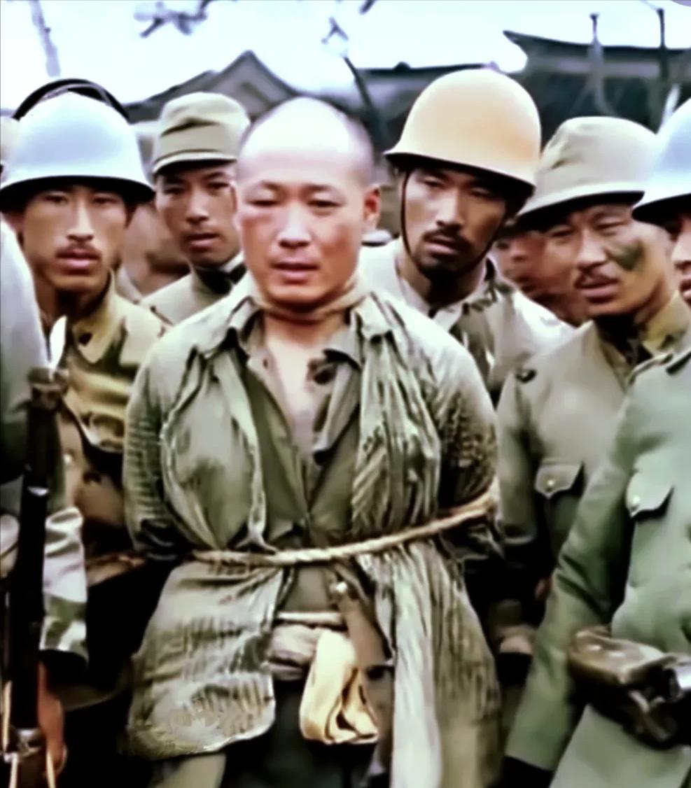 被日军私人收藏的一张照片：日军将押送的中国侦察兵带行刑场的路上。这个汉子尽管被殴
