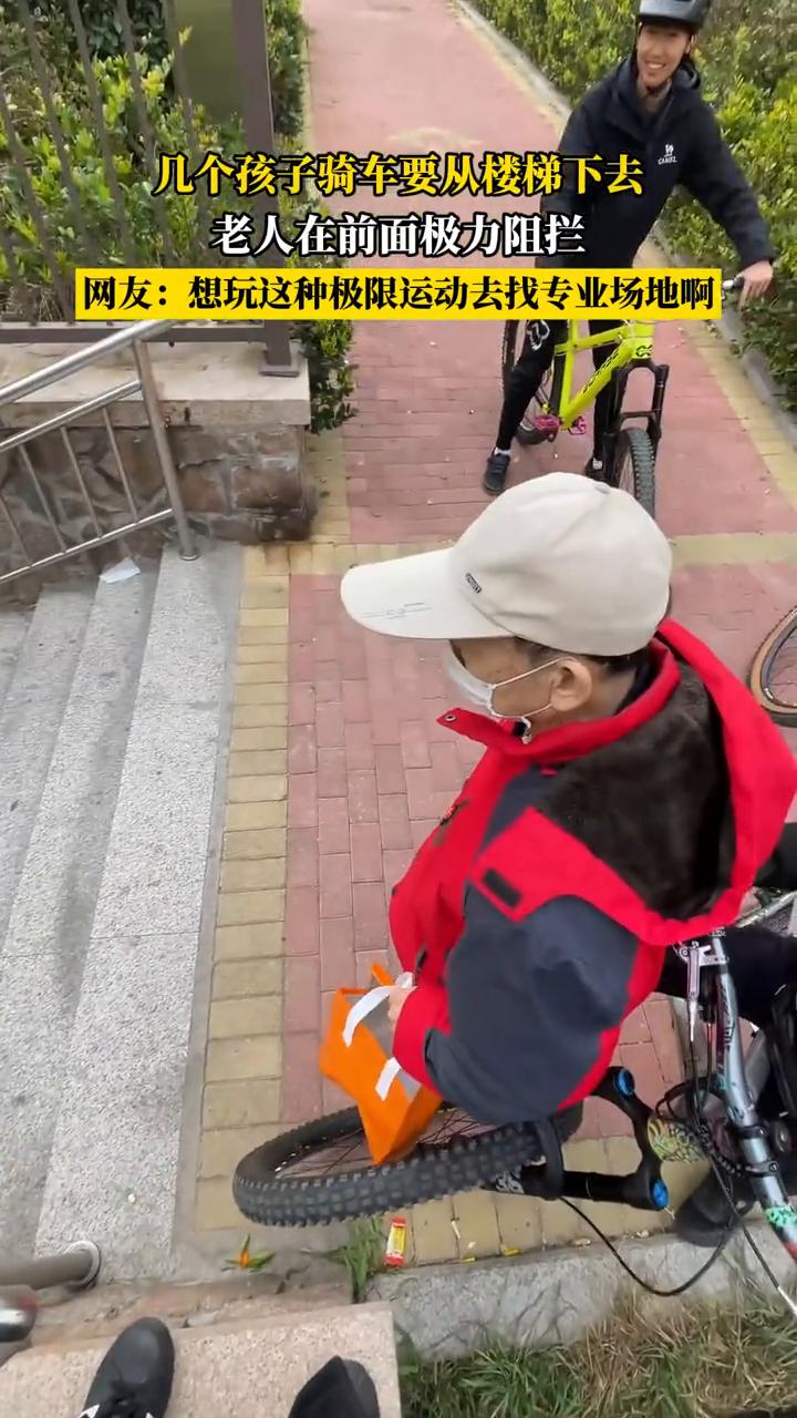 几个孩子骑车要从楼梯下去，老人在前面极力阻拦。网友：想玩这种极限运动去找专业场