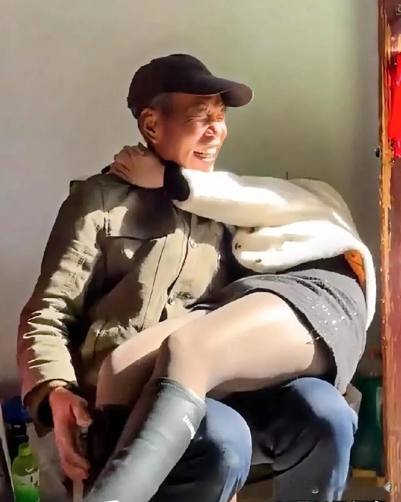 孙女双手搂着爷爷的脖子坐在他腿上，本来是想着跟爷爷撒个娇，可没想到坐上去那一刻，