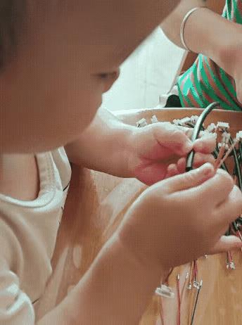 妈妈因为要在家照顾两岁的宝宝不能出去工作，为了补贴家用就拿了一些手工活在家做。宝