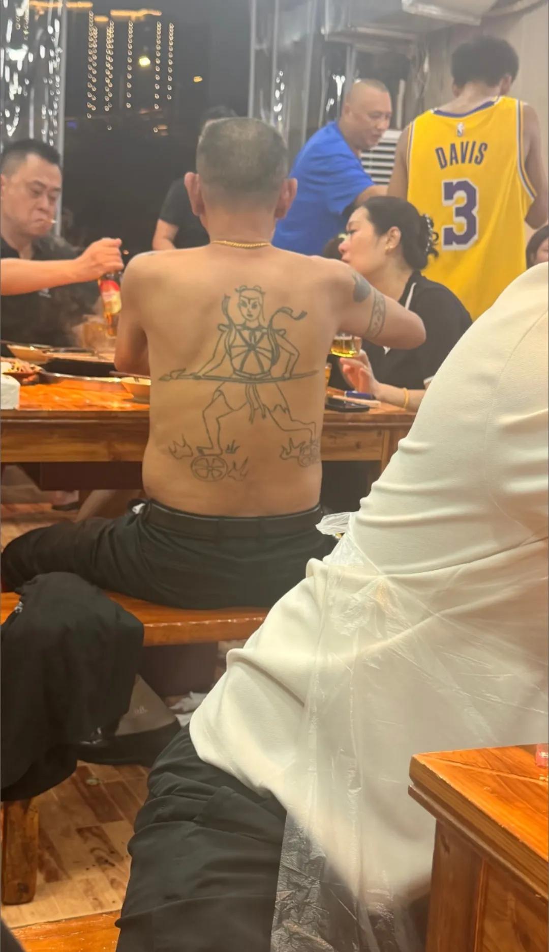 这大哥后背的哪吒纹身太吸睛了，吃个火锅自带“三头六臂”气场，简直酷到没朋友，看起