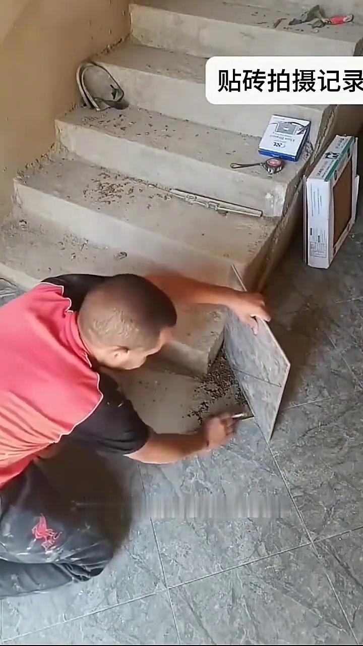 贴砖拍摄记录。这师傅贴砖贴到楼梯角尴尬了，一块砖用不完，半块砖还不够，最后一块