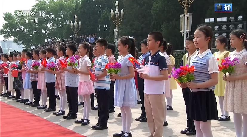 我发现小孩拿的花好像制造的，而且站位是一个男孩，一个女孩，男孩衣服不一样，女孩的