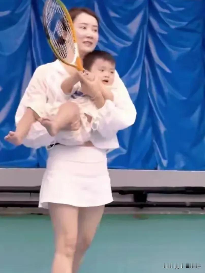 李念带着三胎宝宝打网球，当时15个月大的小家伙被妈妈抱着，手上拿着网球拍。去年六