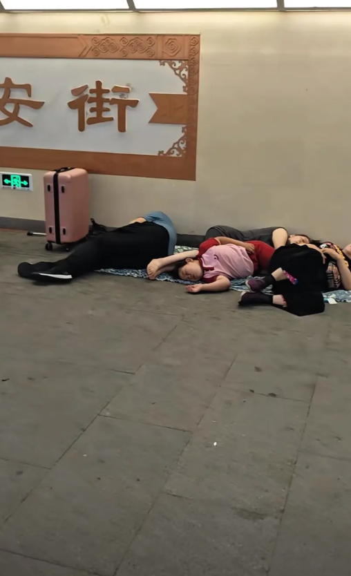 2025年7月11日晚上，北京长安街。地下通道里，一家人正在休息。他们这是为了次