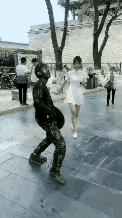 男子在广场搞行为艺术！不想碰到这么个调皮女生！她把自己手中的饮料用吸管儿吸满后吐