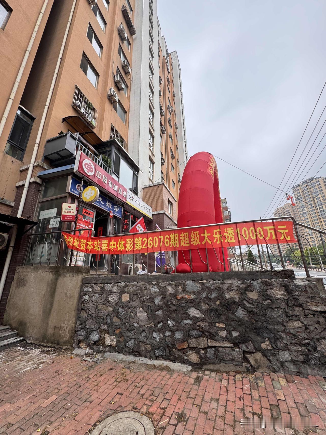 我们小区的彩票站，有人中了大乐透的一千万大奖。彩票站老板在门口放置了一个彩虹