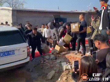 河北一对新人结婚当天，新郎还坐在车上时，就被一群朋友拉下了车，随后众人抱着一箱箱