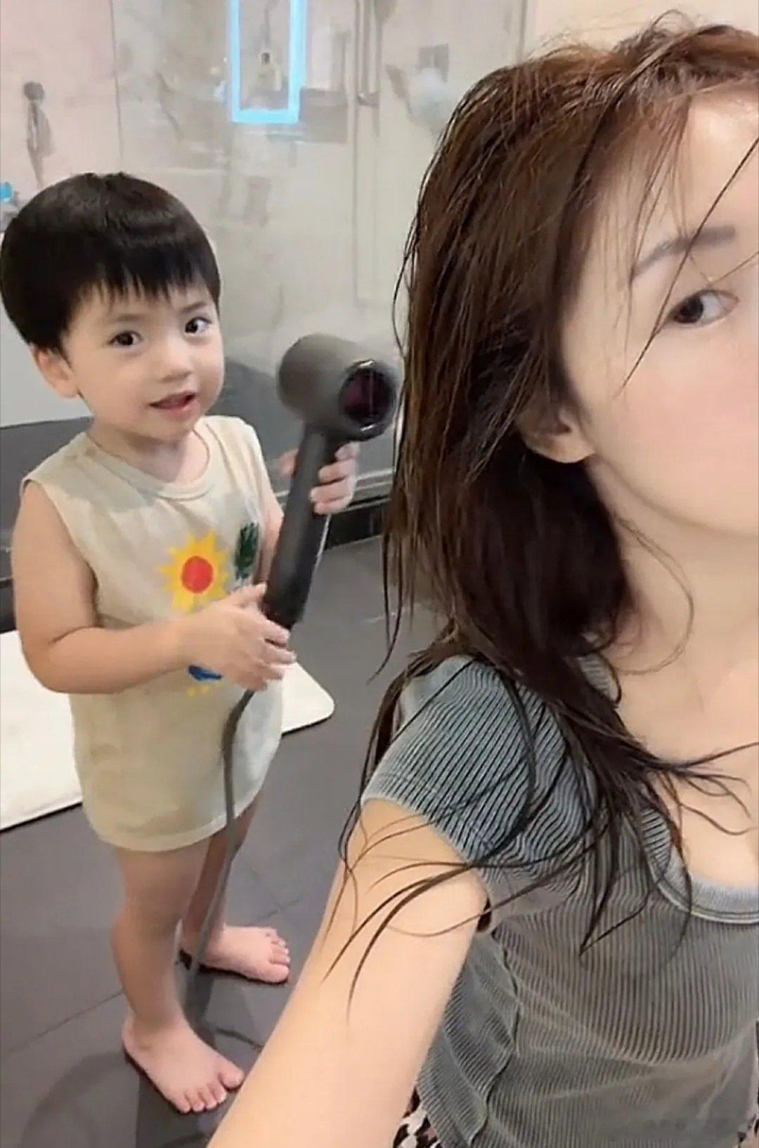 “海藻”李念晒三胎宝贝，3岁儿子拿着吹风机帮妈妈吹头发，李念蹲在地上配合，刚洗完