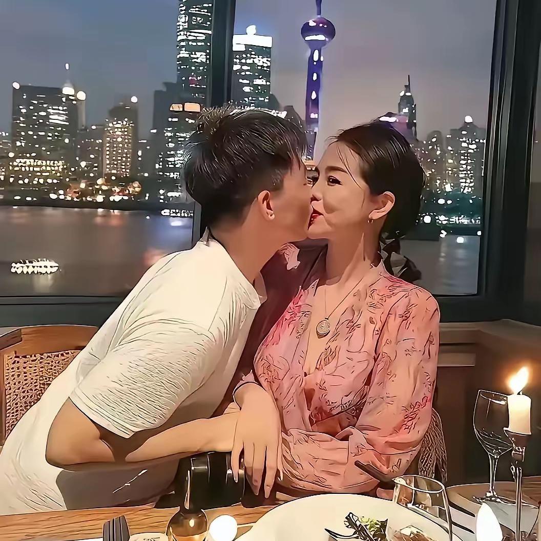大家看，在上海的黄浦江边上，一位将近50岁的大妈和一位00后小伙尽情秀恩爱，别看