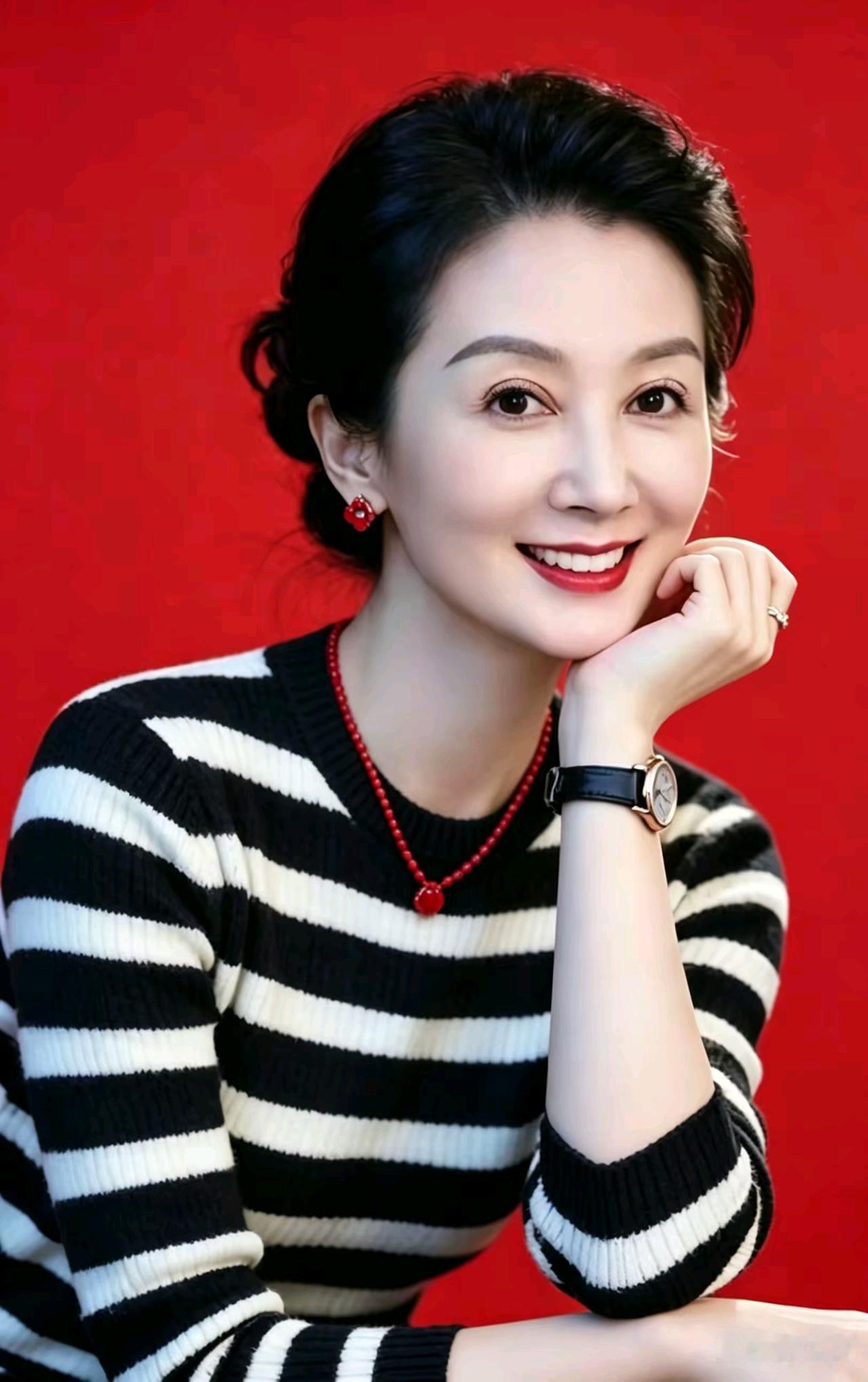 红底妆成俏佳人，黑白横纹衣色新。耳饰玲珑增秀色，笑如暖日动人心。玉手轻托