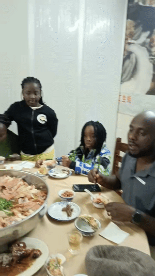 黑人一家人在广州一家餐厅里吃饭。看他们吃的东西好像还是“海鲜大伽”？由于点的