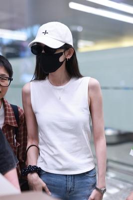 古力娜扎现身机场白色无袖背心配牛仔裤清爽时尚，随性简约棒球帽的加入多了