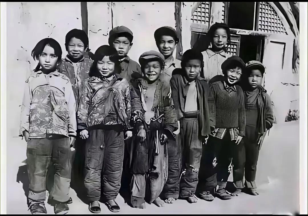 据说这张照片拍摄于1980年，地点是山西省吕梁某个农村，一群小学生站在窑洞前。这
