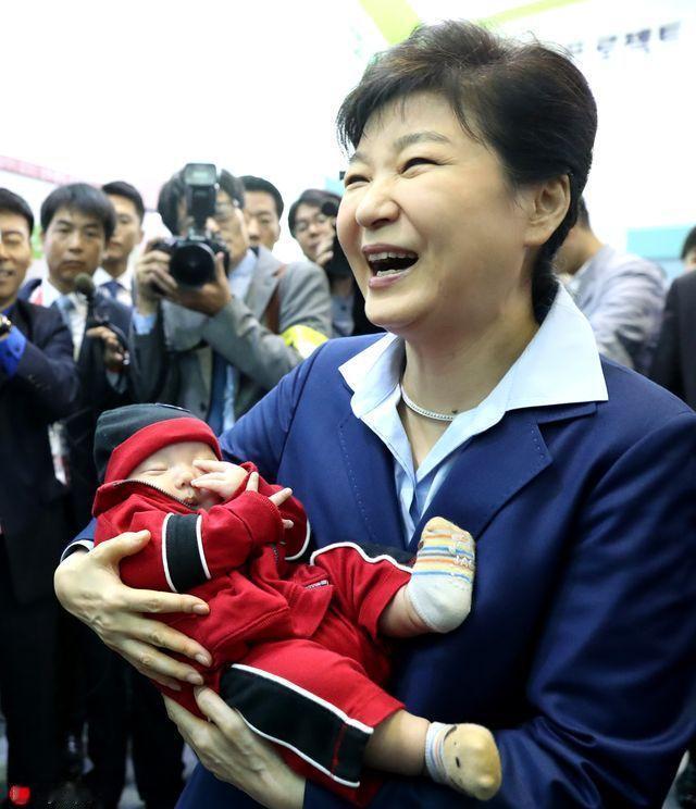 朴槿惠怀中的娃娃长得好像她，她抱着娃娃笑呵呵，不知道的人还以为是奶奶抱着孙子乐开