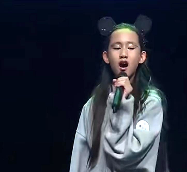 黄磊当年留着长发唱《我想我是海》的模样，居然被自家二女儿给彻底演活了。多妹顶着一头扎眼的绿发，抓着麦