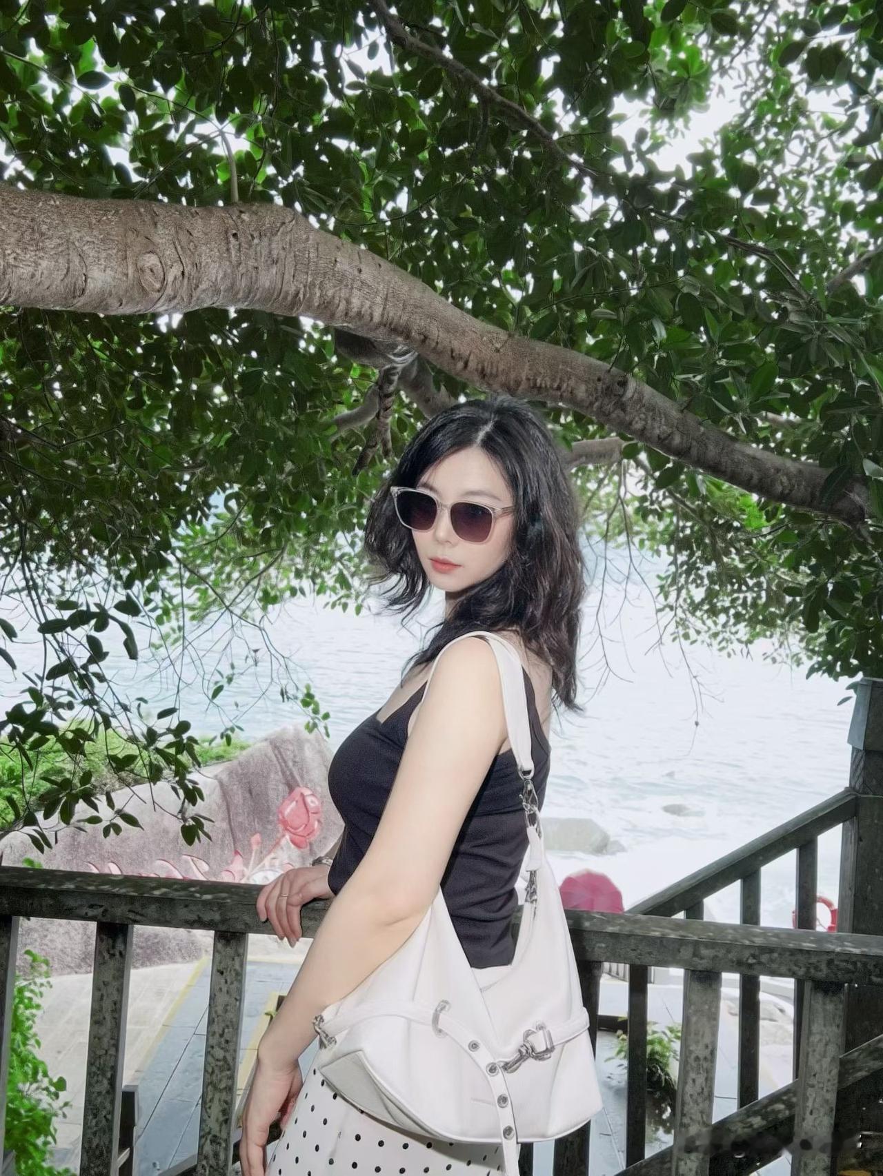 一位戴墨镜的女士在海边散步