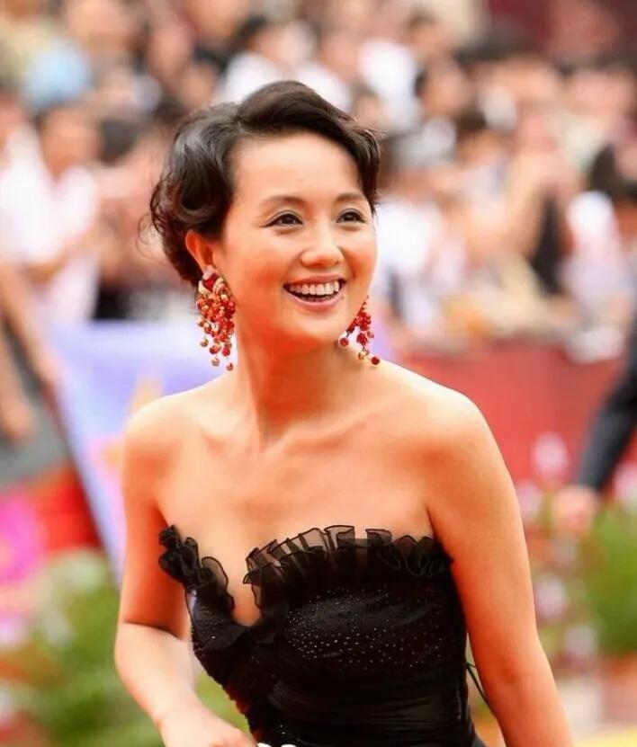 32岁的朱媛媛也是貌美如花，娇俏活泼，穿着黑色抹胸小礼服，头发盘起来，戴着红色耳