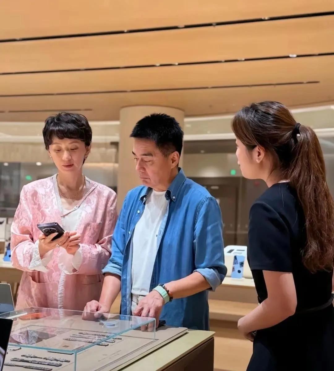 许亚军陪第三任小娇妻张澍现身手机店买手机时的一幕，店员在一旁介绍产品。许亚军是家