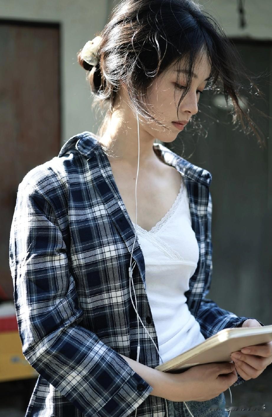 阳光下的少女，耳机里流淌着音乐，沉浸在书海中。