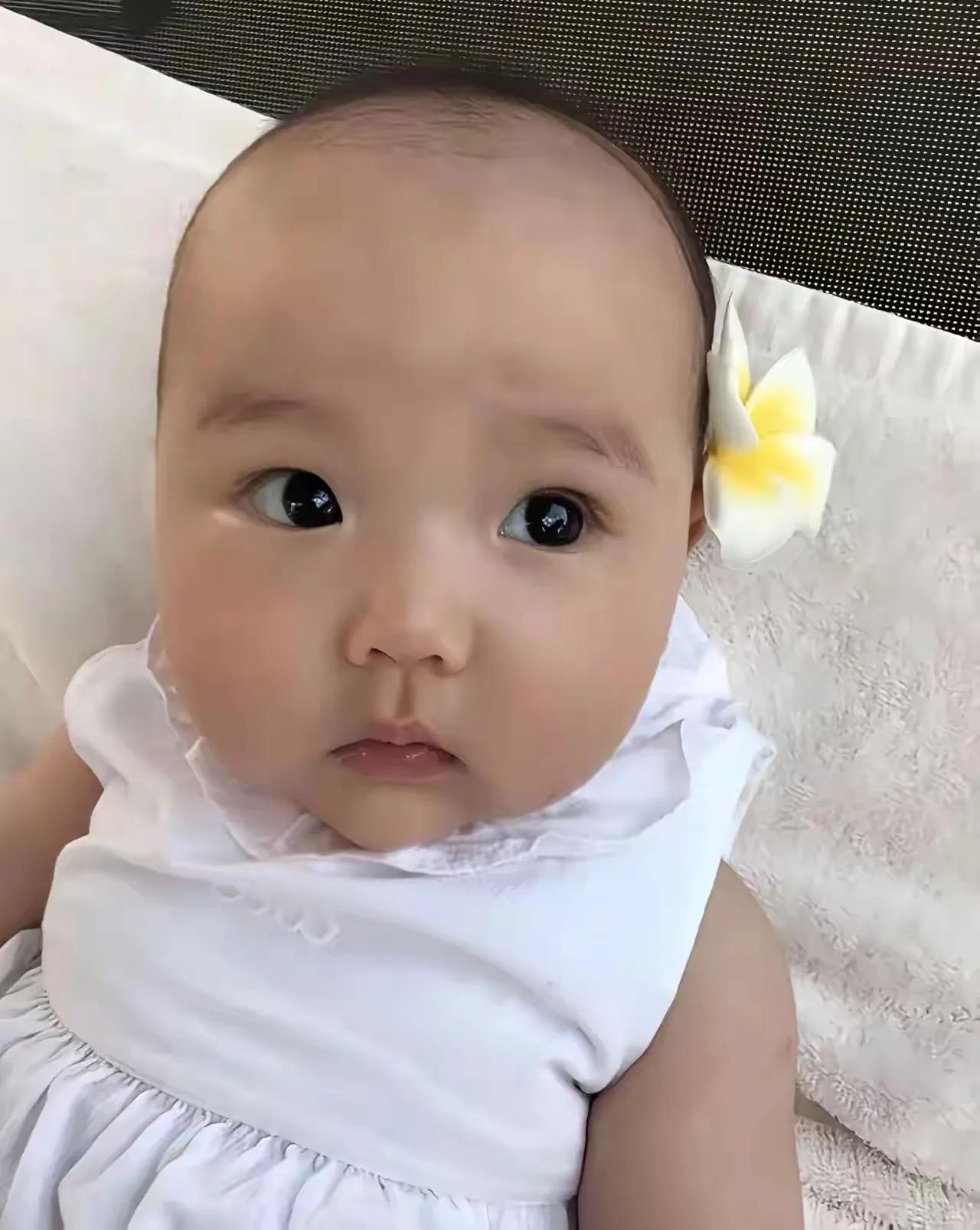 小酒窝那会头发短短似光头，别着花儿的她萌萌哒。生个女儿将她打扮成公主是每个妈妈的