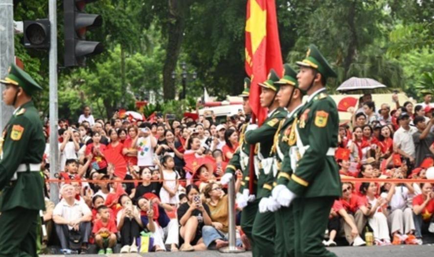 越南首都的河内街头，挤满观看阅兵彩排的市民。你还别说，虽然道路不算繁华，但是气氛