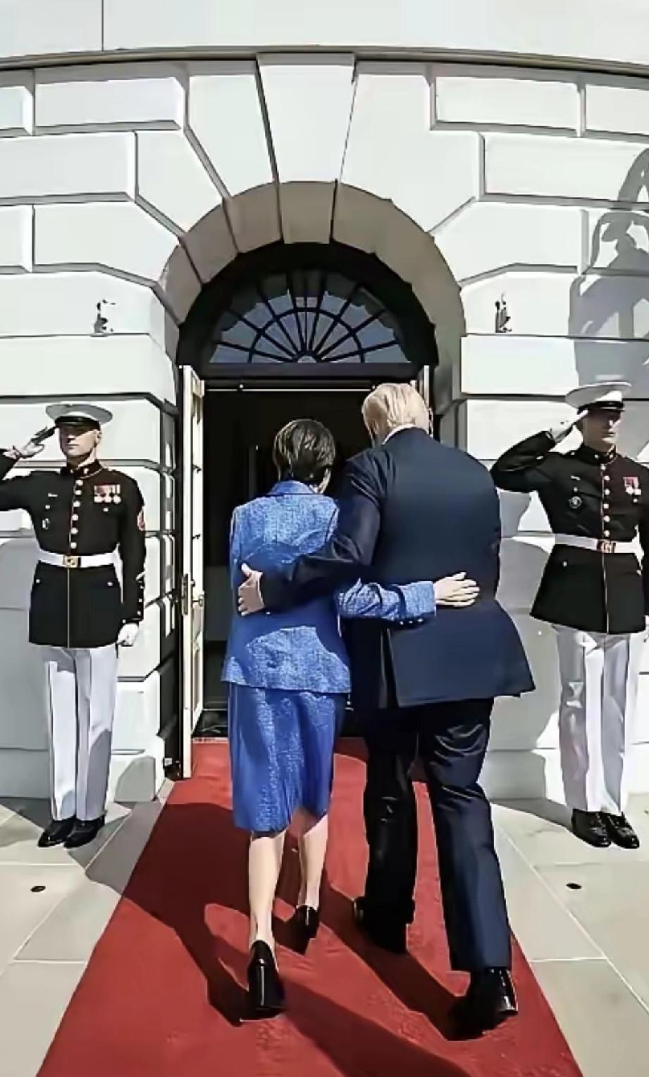 这是两位老人的背影，拍摄的意境很唯美。白头发的男人穿一身黑西装，短发的女人穿一