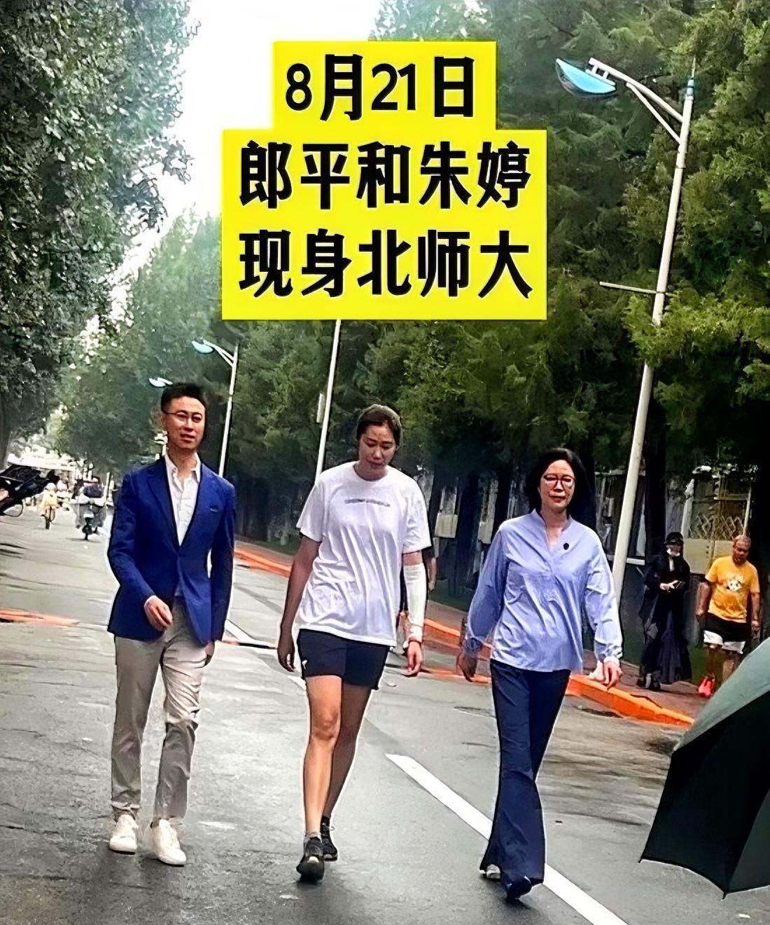 郎平朱婷北师大雨中漫步，央视主持人邵圣懿全程陪同，三人走在林荫道上，谈笑风生。中