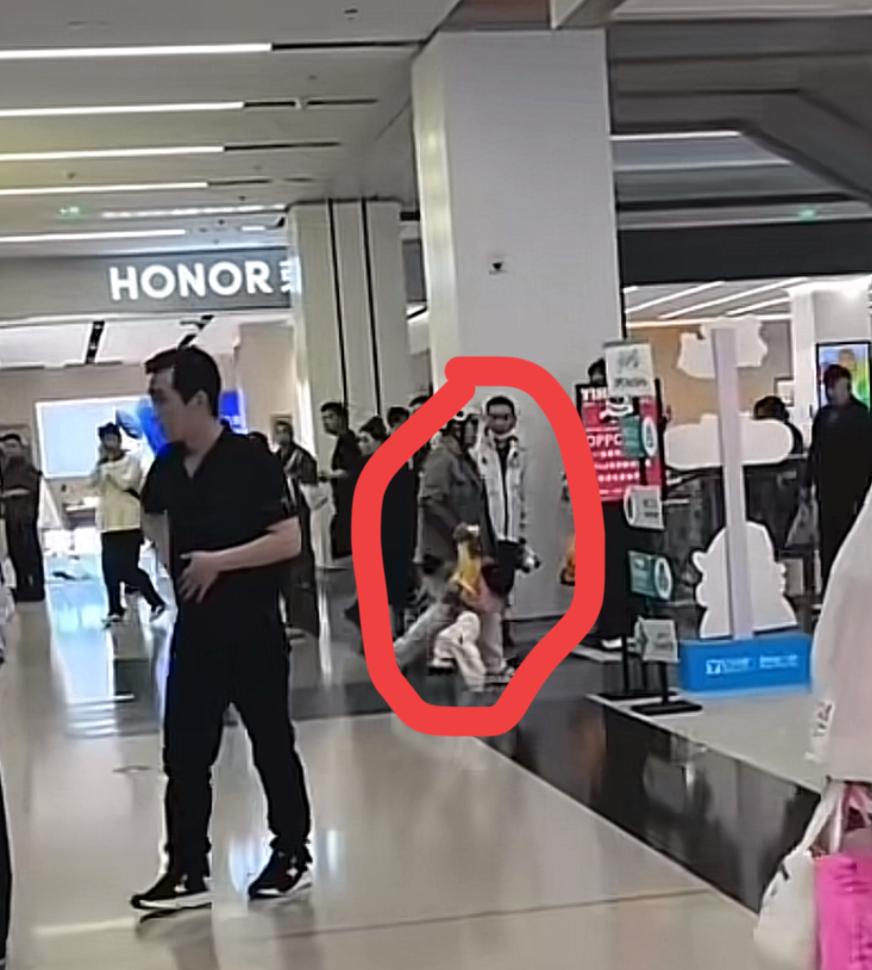 商场里22岁的妈妈带着两岁的孩子送外卖，因为孩子不断的哭闹，妈妈的手里还拿着三份