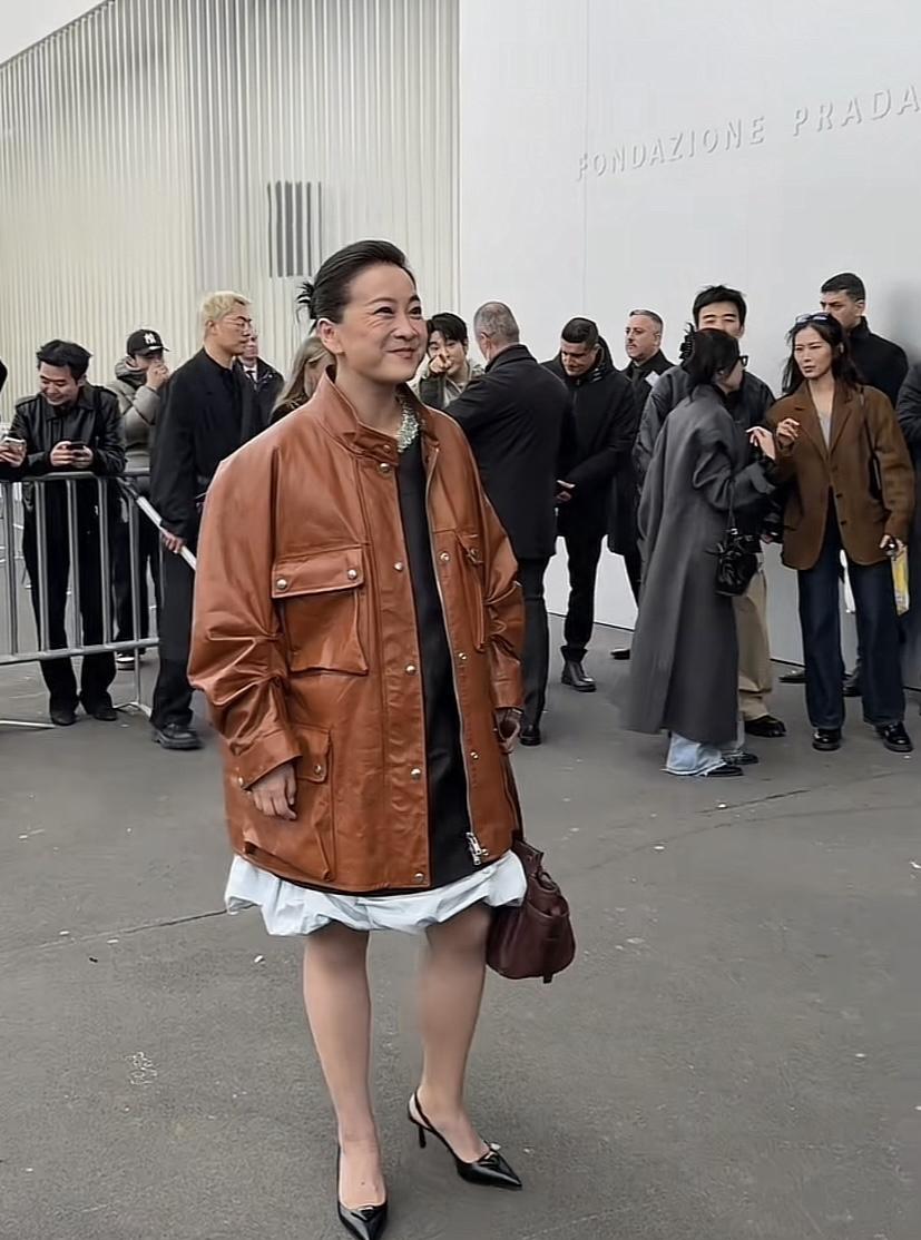 米兰。她转身的瞬间，棕色皮衣下摆甩出一道冷硬的弧线。咔嚓声淹过来。皮衣是哑